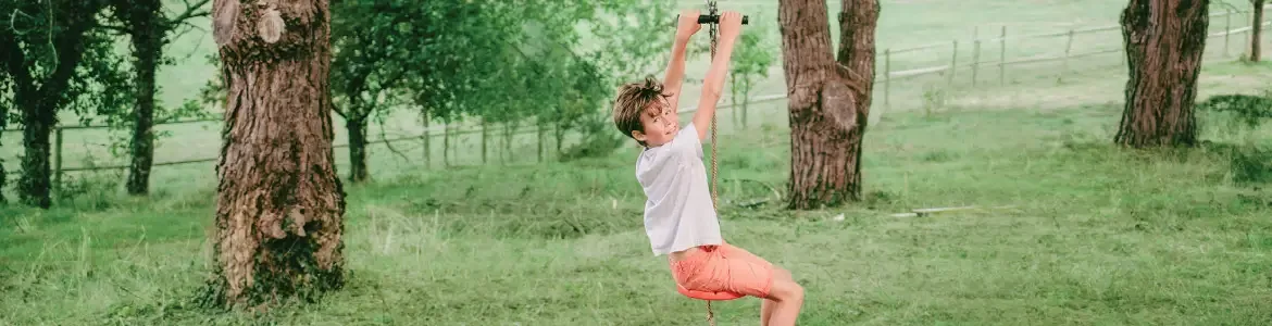 Kind an einer France Trampoline Seilrutsche
